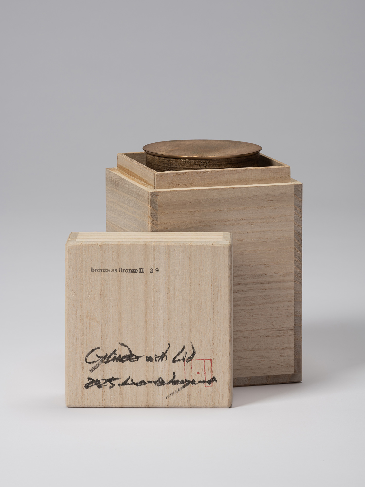 Wooden storage box with its lid removed, revealing the lidded bronze vessel inside. The box lid...