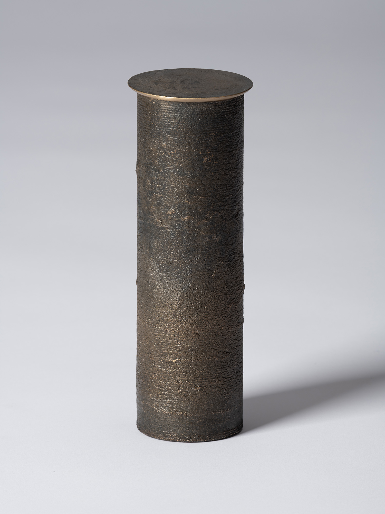 Front view of bronze as Bronze II No. 31 by Koji Hatakeyama, a tall cylindrical bronze vessel with...