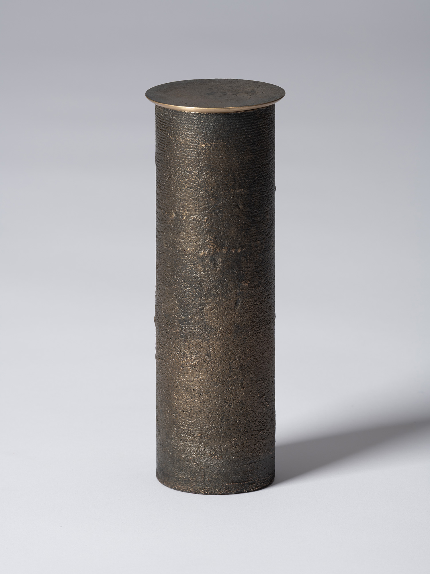 Front view of bronze as Bronze II No. 31 by Koji Hatakeyama, a tall cylindrical bronze vessel with...