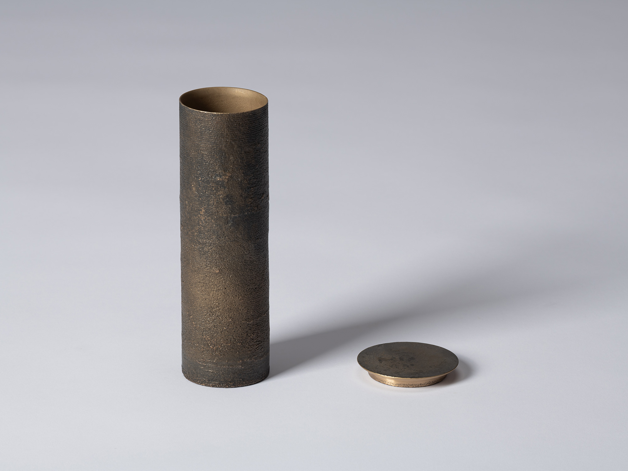 bronze as Bronze II No. 31 by Koji Hatakeyama shown with its lid removed, revealing a warm gold-bronze...