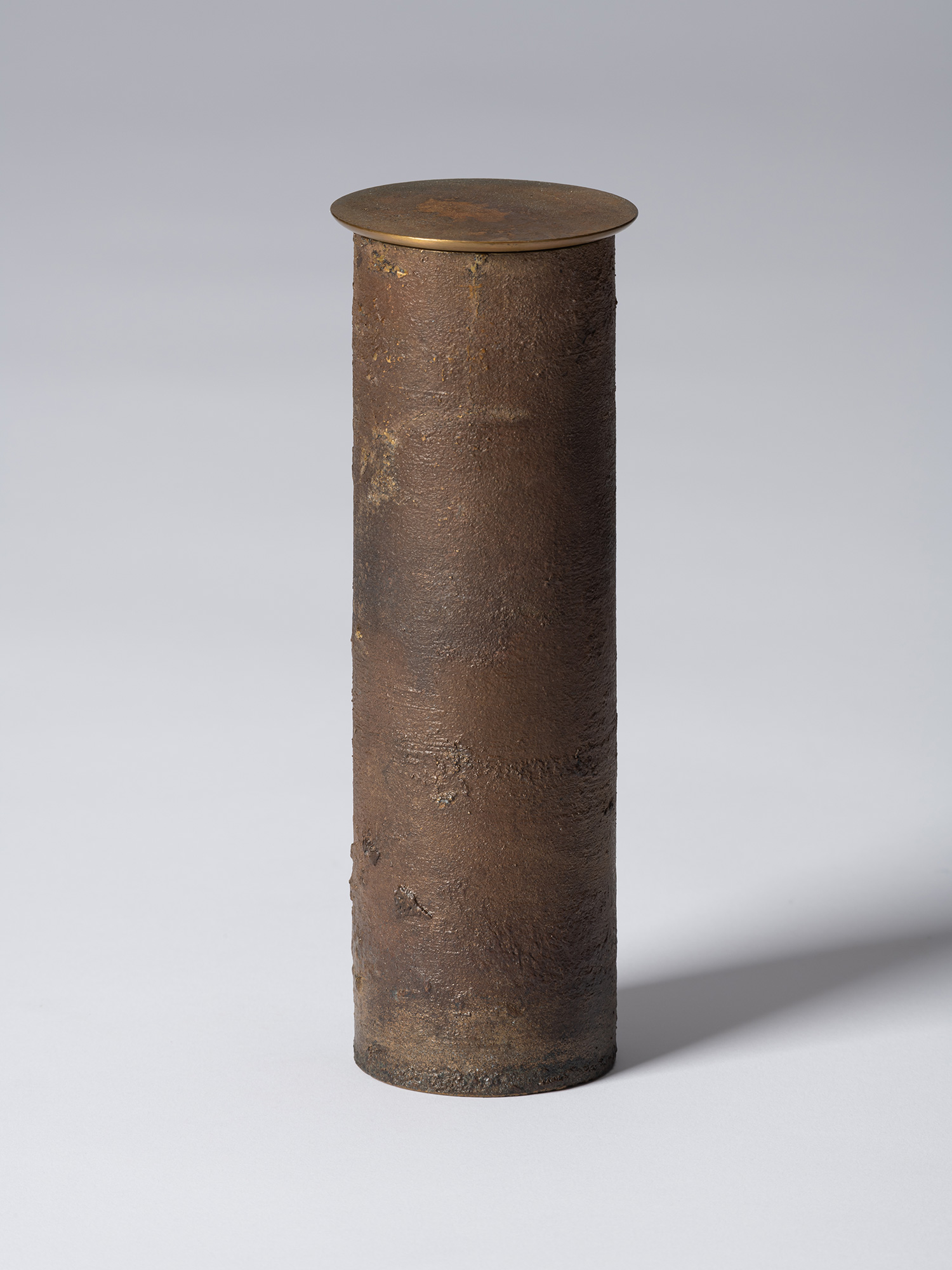 Front view of Koji Hatakeyama’s bronze as Bronze II No. 33, a tall cylindrical bronze vessel with...