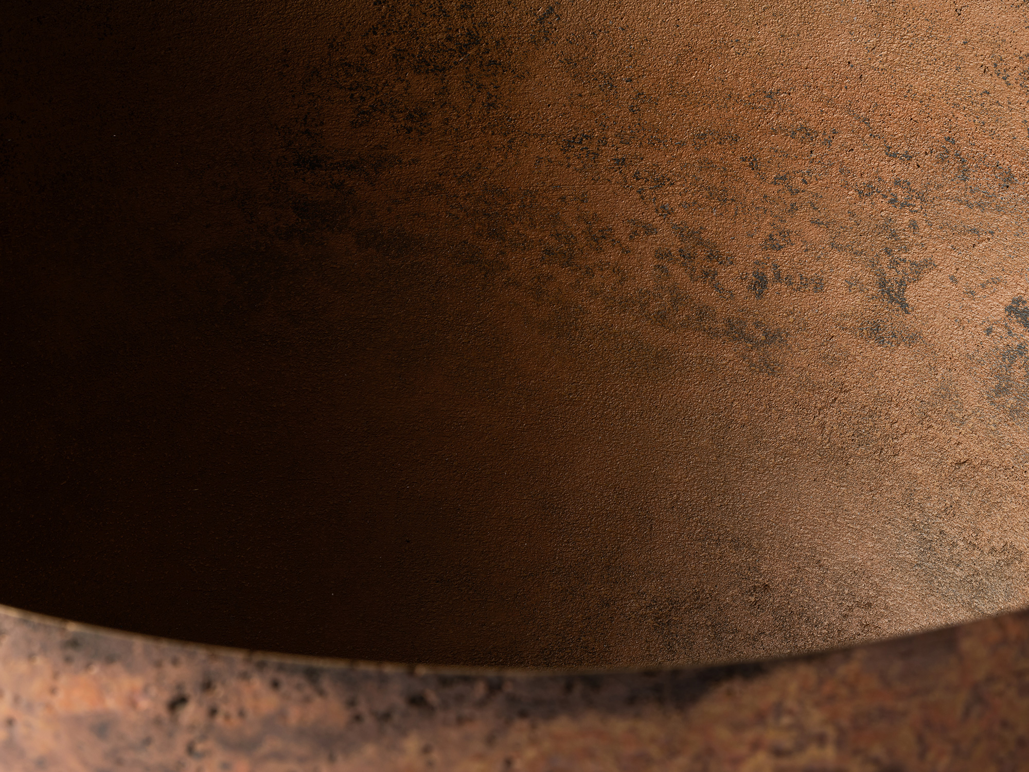 Detail of the vessel’s interior, showing a finely textured bronze surface with warm copper-brown...