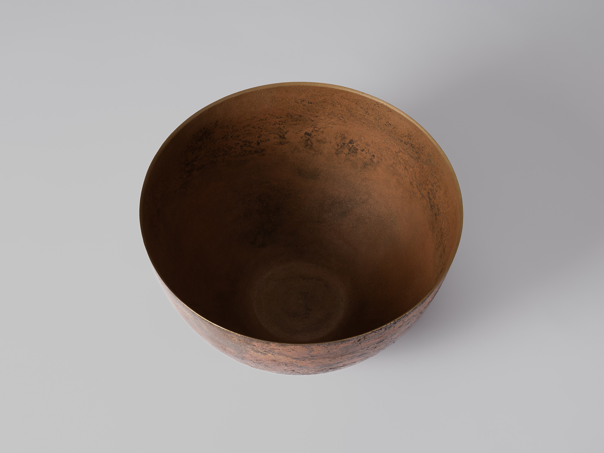 Overhead view of the bronze vessel, showing its broad circular opening, thin rim, and deep interior...