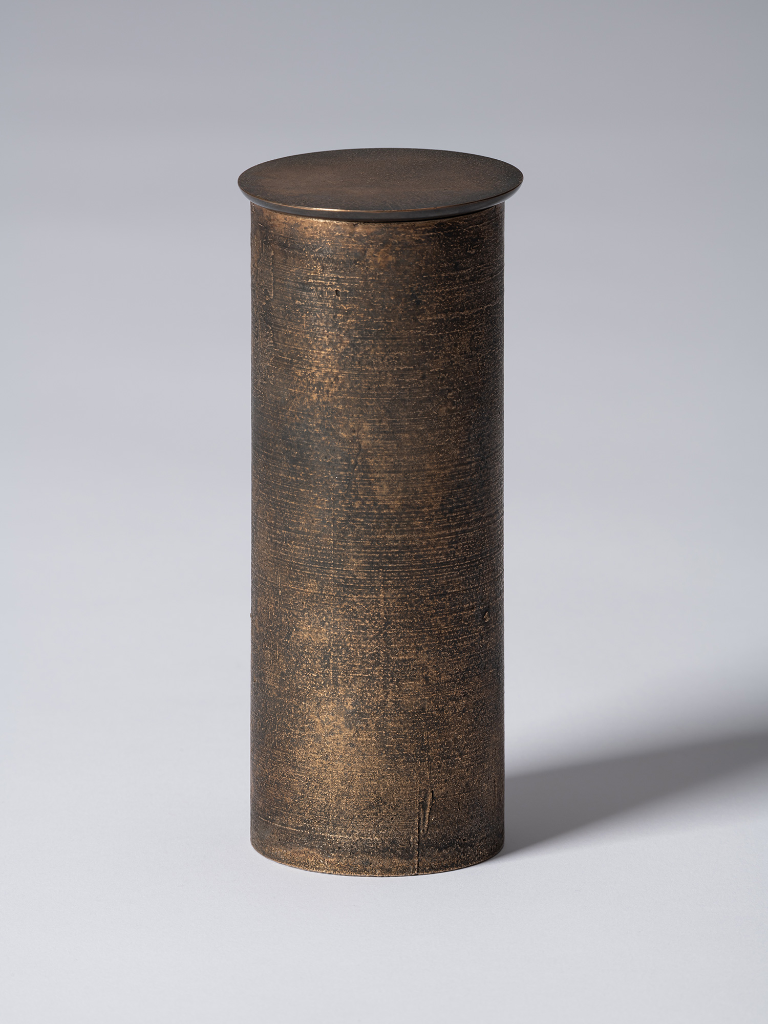 bronze as Bronze II No. 17 by Koji Hatakeyama, a tall cylindrical bronze vessel with a fitted circular...