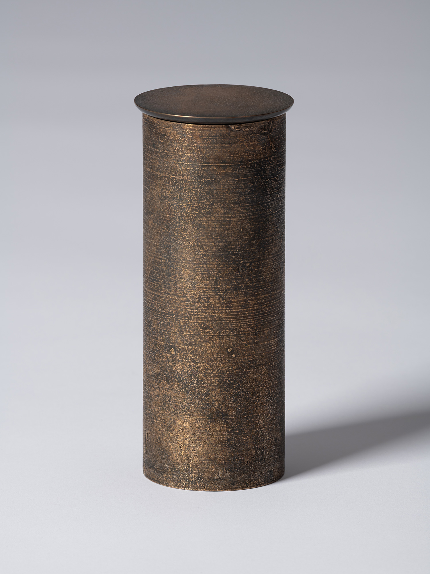 bronze as Bronze II No. 17 by Koji Hatakeyama, a tall cylindrical bronze vessel with a fitted circular...