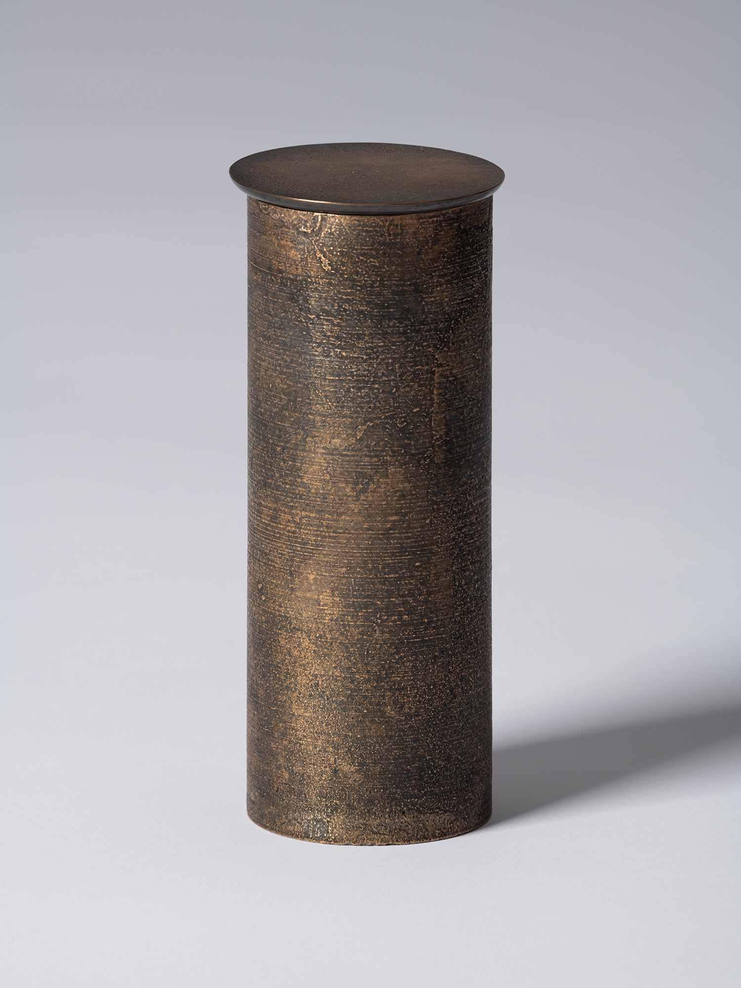 bronze as Bronze II No. 17 by Koji Hatakeyama, a tall cylindrical bronze vessel with a fitted circular...