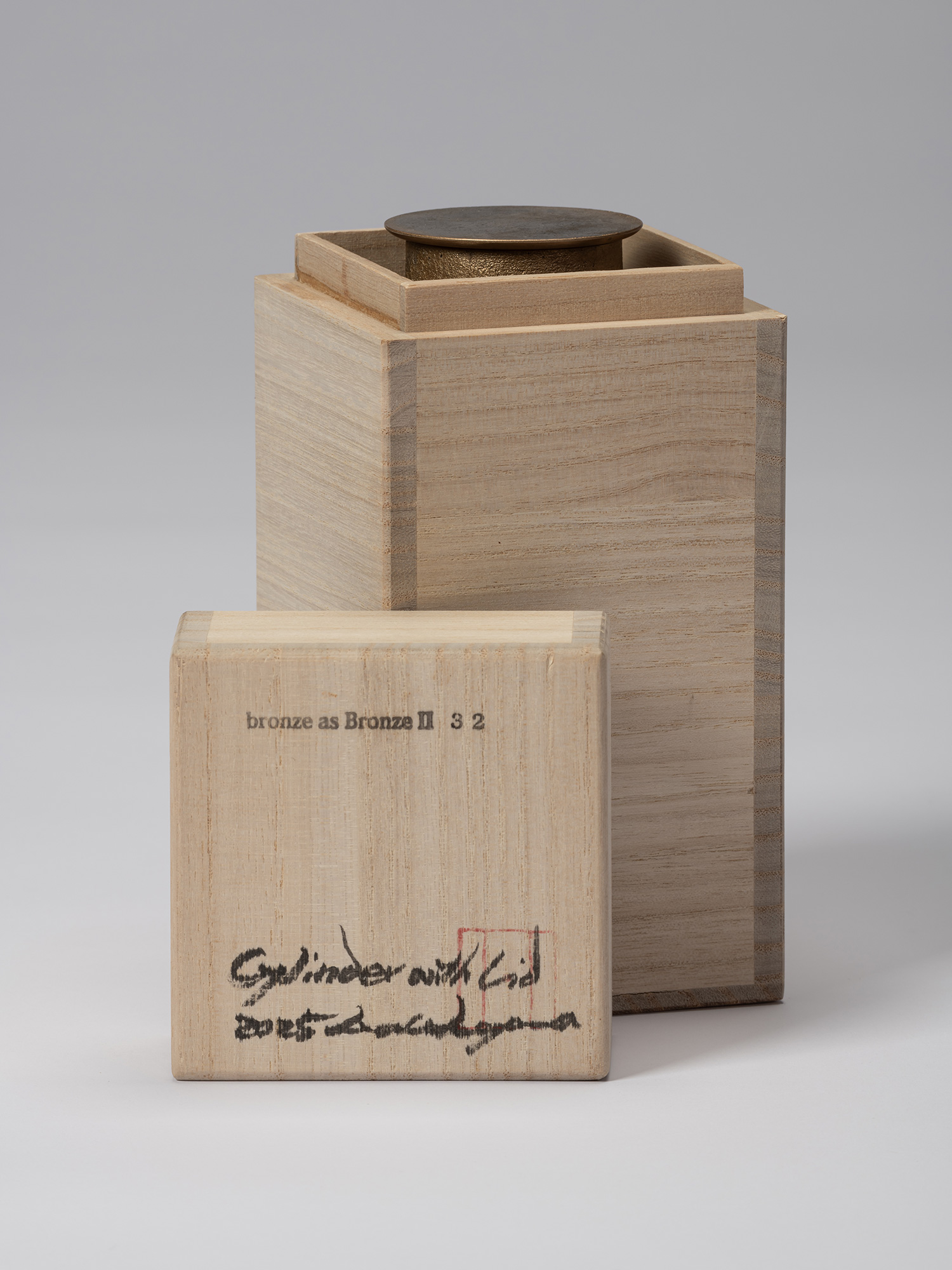 Wooden storage box with its lid removed, revealing the lidded bronze vessel inside. The box lid...