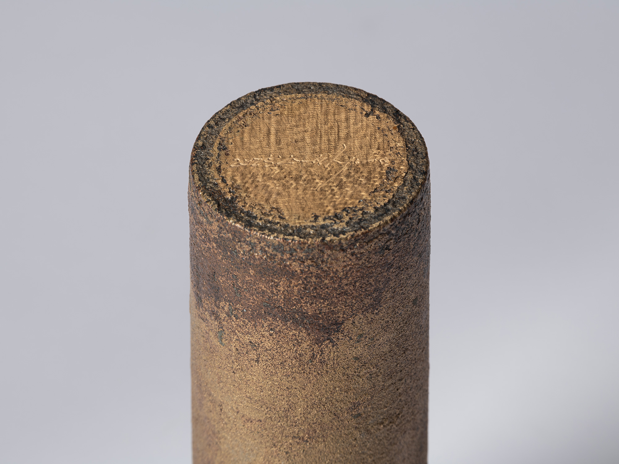 Detail of the underside of the bronze vessel, showing the artist’s incised signature and date on...