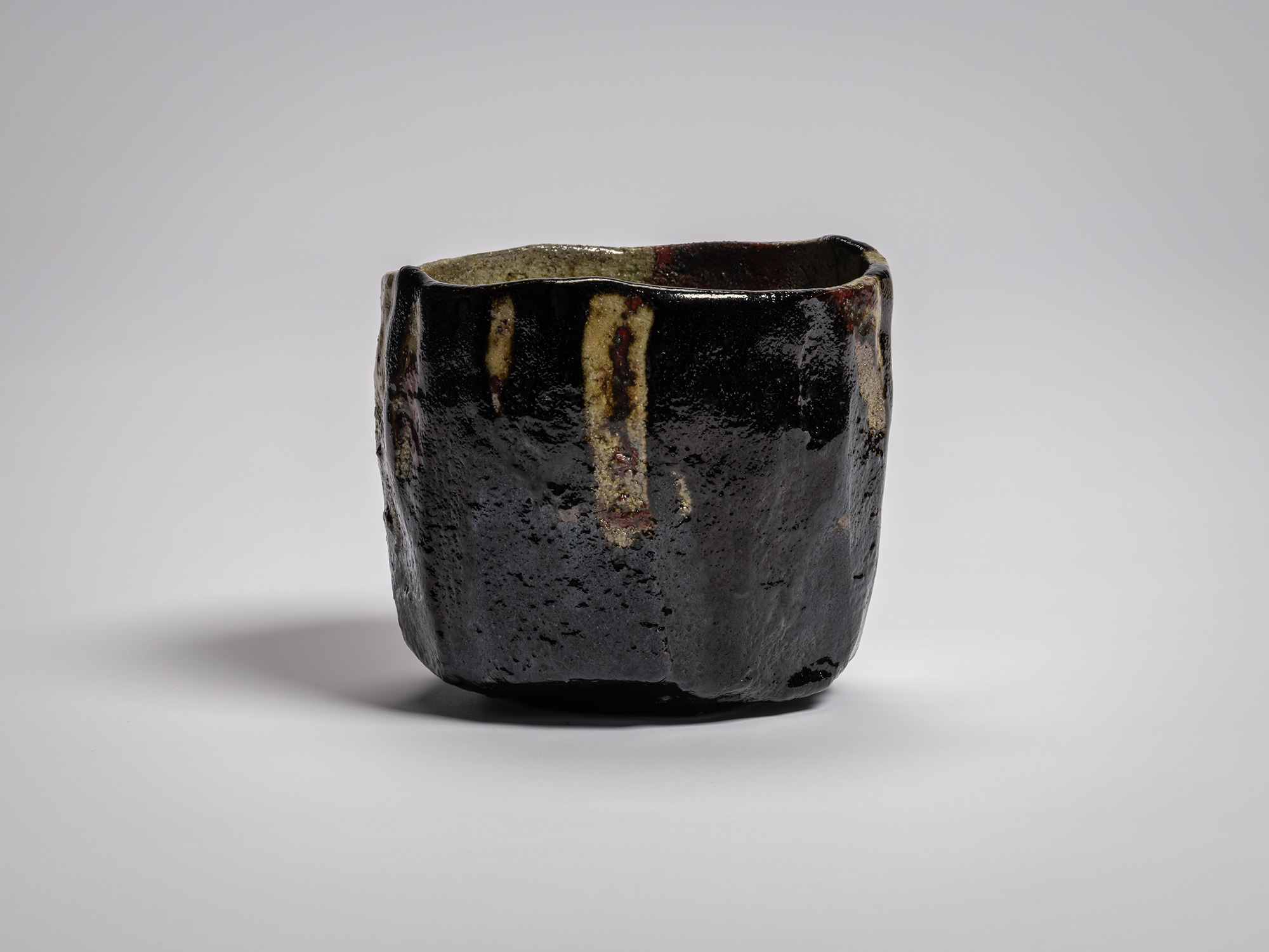 Kōshū (Mountain Peak) by Raku Jikinyū XV, showing a broad surface covered primarily in glossy black...